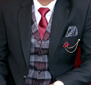 Close-up of a man in an elegant black suit with a red tie and plaid vest, showcasing formal menswear. HD wallpaper