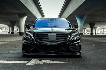 Sleek black luxury car parked outdoors under a modern urban bridge in Sacramento. HD wallpaper