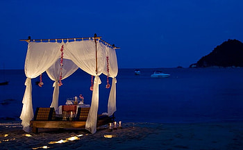 Night of romance, night, blue, dinner, wineglasses, sand, cabana, lanterns, evenong, beach, boats, glasses, candles, hill, white, mats, romance, ships, light, honeymoon, flowers HD wallpaper