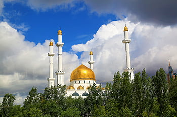 A stunning view of a grand mosque with a golden dome in Astana, Kazakhstan, under a vibrant blue sky. HD wallpaper