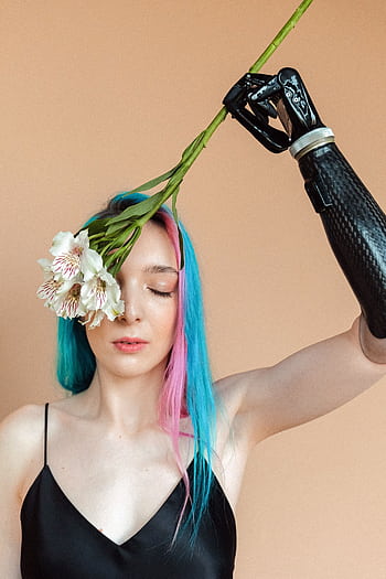 A captivating portrait of a woman with a prosthetic arm holding flowers, showcasing beauty and resilience. HD phone wallpaper