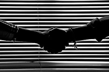 Silhouette of two people shaking hands symbolizing partnership and trust. HD wallpaper