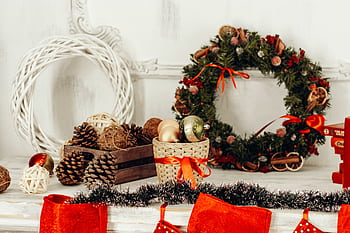 Charming Christmas display featuring a wreath, ornaments, and pine cones for holiday decor. HD wallpaper