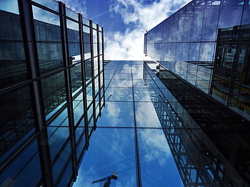 Perspective view of modern skyscraper facades with glass reflections of clouds and sky. HD wallpaper