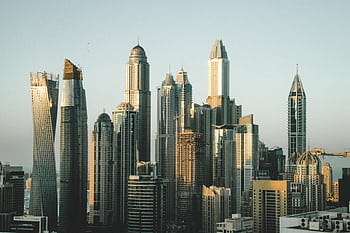 A stunning view of the modern Dubai skyline with towering skyscrapers under a clear sky captured during the day. HD wallpaper