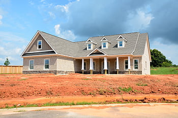 Brick modern family home under bright sky, showcasing new construction and architectural style. HD wallpaper