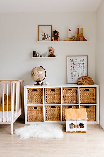 Cozy nursery room featuring wicker storage baskets, wall decorations, and a neutral color palette. HD phone wallpaper