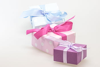 A trio of pastel gift boxes tied with vibrant ribbons, perfect for celebrations. HD wallpaper