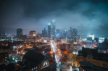 Stunning nighttime view of the Indianapolis skyline with illuminated skyscrapers and a bustling street below. HD wallpaper