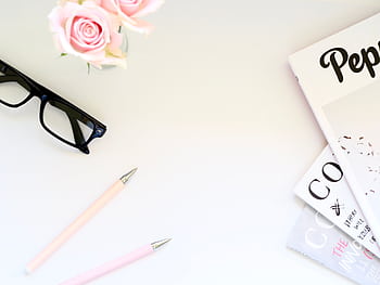 A stylish flat lay of workspace essentials featuring pink roses, magazines, and eyeglasses. HD wallpaper