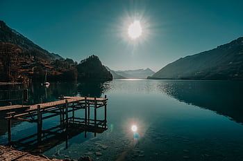 Scenic view of a tranquil lake and mountains at Interlaken, captured under bright daylight reflecting the serene natural beauty. HD wallpaper