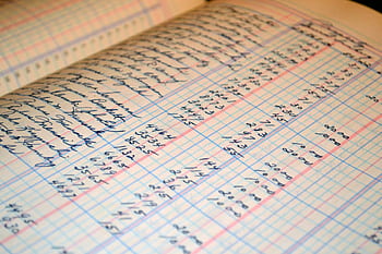 Close-up of a vintage handwritten ledger detailing financial records and accounts. HD wallpaper