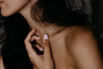 Artistic close-up of a woman's neck and hand with a focus on skin texture and nails. HD wallpaper