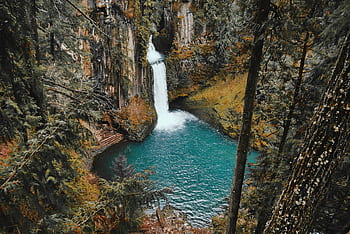 Breathtaking view of a waterfall in a lush forest setting cascading into a turquoise pool. HD wallpaper