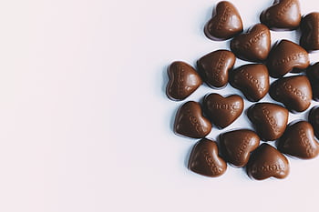 Flat lay of heart-shaped milk chocolates with 'merci' text, perfect for gifting. HD wallpaper
