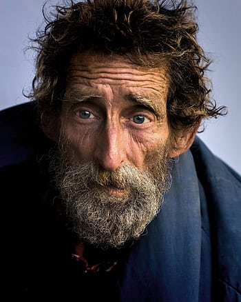 Close-up portrait of a senior man with a beard, capturing a deep, reflective expression. HD phone wallpaper