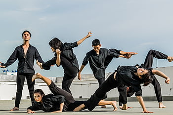Energetic group performing synchronized martial arts on a rooftop. HD wallpaper