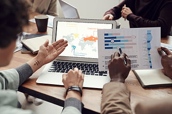Professional team discussing analytics and brainstorming ideas in a meeting room. HD wallpaper