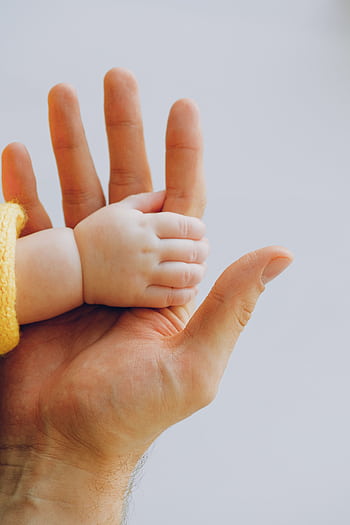 Tender moment captured between a baby and parent's hands symbolizing love and trust. HD phone wallpaper