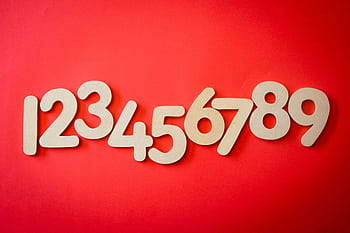Creative display of numbers one to nine on a vibrant red background, ideal for educational materials. HD wallpaper