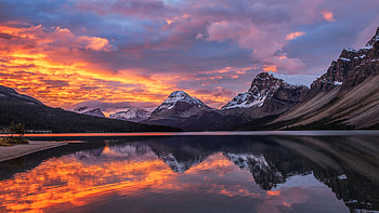 Landscape View Of Snow Covered Mountains Under White Clouds Sky During Sunset Reflection On Lake Sunset HD wallpaper