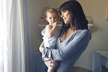 A loving moment between a mother and her child in an indoor setting, fostering connection and warmth. HD wallpaper