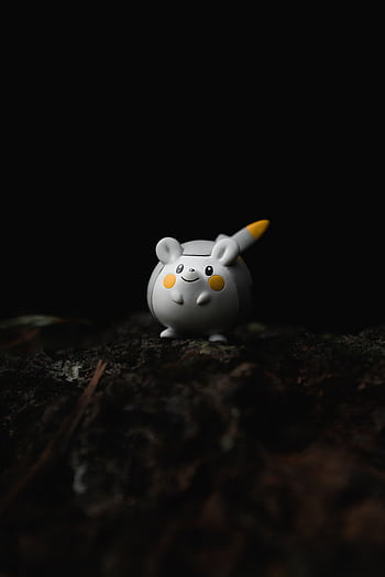 A small cartoon mouse toy with yellow accents sits on a dark surface. Perfect for playful themes. HD phone wallpaper