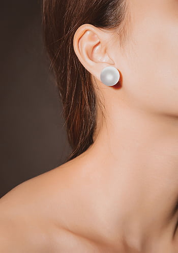 A close-up of an elegant pearl earring on a woman's ear, displaying grace and style. HD phone wallpaper