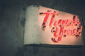Retro neon 'Thank You' sign glowing warmly against a rustic wall, creating a nostalgic ambiance. HD wallpaper