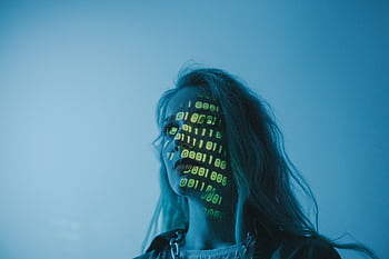 A woman with binary code lights projected on her face, symbolizing technology. HD wallpaper