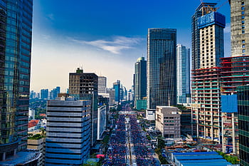 Stunning aerial view of Jakarta's modern skyline with bustling streets below. HD wallpaper