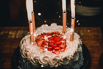 Celebrate with a festive strawberry-topped birtay cake adorned with sparkler candles, creating a joyful atmosphere. HD wallpaper