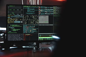Close-up of a computer monitor displaying cyber security data and code, indicative of system hacking or programming. HD wallpaper