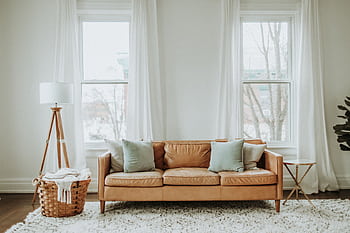 A cozy minimalist living room with a leather sofa and stylish decor. HD wallpaper