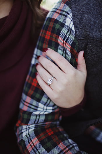 Close-up shot of engagement ring on a woman's hand holding her partner's arm, symbolizing love. HD phone wallpaper