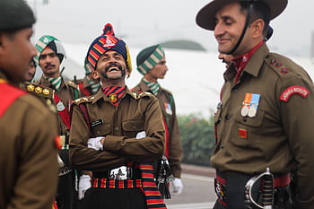 Indian soldiers in uniform sharing laughter during a celebration, showcasing camaraderie and patriotism. HD wallpaper