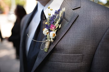 Close-up of an elegant groom wearing a designer suit and floral boutonniere during a wedding ceremony. HD wallpaper