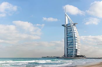 Stunning view of Burj Al Arab with a serene beach setting in Dubai, UAE. HD wallpaper