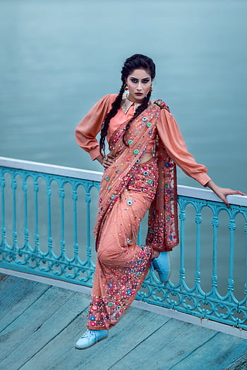 Elegant Indian woman posing on a dock in a vibrant traditional sari and modern blouse, Hyderabad. HD phone wallpaper