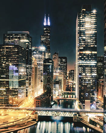 Capture of Chicago's urban skyline at night, showcasing illuminated skyscrapers along the river. HD phone wallpaper