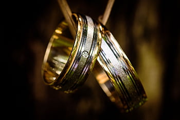Close-up of luxurious gold wedding rings with a diamond detail, perfect for wedding themes. HD wallpaper