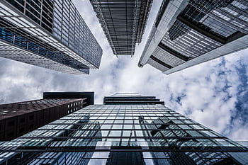 A striking upward view of modern skyscrapers in Frankfurt showcasing architectural elegance against a cloudy sky. HD wallpaper