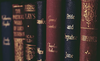 Vintage classic literature books lined up neatly on a bookshelf HD wallpaper