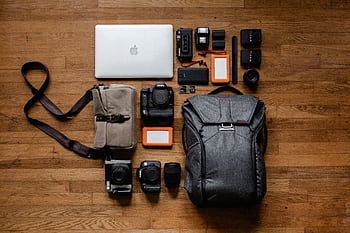 High-angle shot of camera equipment and laptop arranged on wooden floor for graphy setup. HD wallpaper