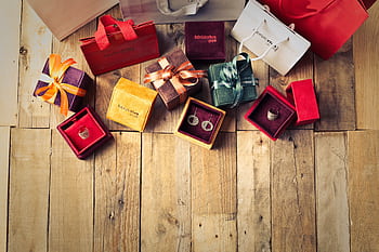 Elegant jewelry gifts with shopping bags on wooden floor, perfect for holiday celebrations. HD wallpaper