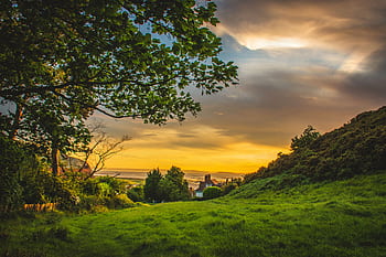 A que sunset over the lush, green countryside of Deganwy, Wales, capturing nature's beauty. HD wallpaper
