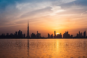 Enchanting view of Dubai's skyscrapers at sunset with the iconic Burj Khalifa outlined against the vivid sky. HD wallpaper
