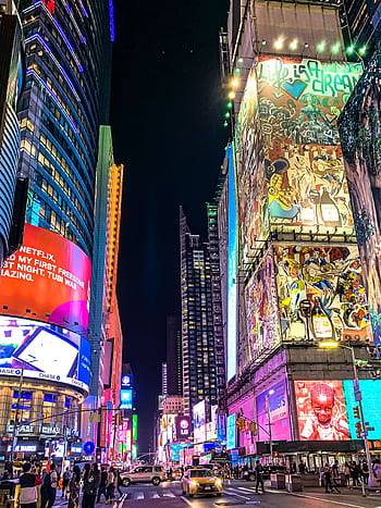 Immersive view of Times Square's nightlife with vibrant billboards and bustling traffic. HD phone wallpaper