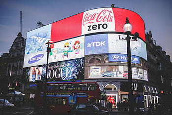 Night view of Piccadilly Circus in London with bright billboards and a red double-decker bus. HD wallpaper