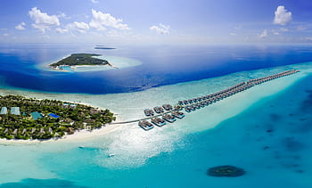 Breathtaking aerial view of Maldives island resorts with azure waters and lush greenery. HD wallpaper